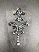 Load image into Gallery viewer, This vintage-inspired coffin ring box will make a spooky yet cute addition to any jewelry collection. The sleek black box has eye-catching black and gray embellishments, while the interior is beautifully decorated with a vivid turquoise blue fabric and a highly detailed black and silver cross with dark red roses. Function and style meet with this unique and stylish piece.
