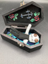 Load image into Gallery viewer,  Skinny black and white Voodoo Doll stands at 3 7/8&quot; in height. Black torso and legs with white arm and head.  Stylish brown buttons for eyes, but his lips are sowed shut of course.
