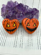 Load image into Gallery viewer, Perfect cute and spooky Halloween item to add to your fridge, locker, cubicle or toolbox.   This hand-crafted bright orange heart-shaped magnet showcases a Jack o Lantern inspired design.  Measurements: H 1 1/2” x W 1 5/8” x D 1/2”
