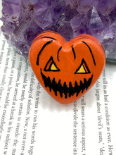 Load image into Gallery viewer, Perfect cute and spooky Halloween item to add to your fridge, locker, cubicle or toolbox.   This hand-crafted bright orange heart-shaped magnet showcases a Jack o Lantern inspired design.  Measurements: H 1 1/2” x W 1 5/8” x D 1/2”
