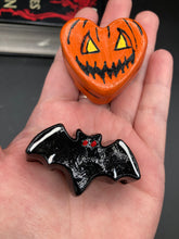 Load image into Gallery viewer, Perfect cute and spooky Halloween item to add to your fridge, locker, cubicle or toolbox. This hand-crafted bright orange heart-shaped magnet showcases a Jack o Lantern inspired design. Black bat magnet with white highlights with red eyes.

