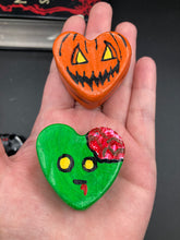 Load image into Gallery viewer, Perfect cute and spooky Halloween item to add to your fridge, locker, cubicle or toolbox.   This hand-crafted bright orange heart-shaped magnet showcases a Jack o Lantern inspired design. Cute green heart-shaped zombie with exposed brain magnet.  Measurements: H 1 1/2” x W 1 5/8” x D 1/2”
