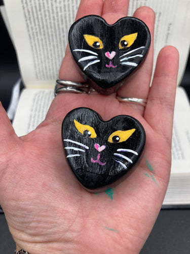 Perfect cute and spooky Halloween magnet art to add to your fridge, locker, cubicle or toolbox.  This hand-crafted heart-shaped magnet features a figurine of a black cat with distinctive yellow eyes. Measurements: H 1 1/2” x W 1 5/8” x D 1/2”