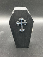 Load image into Gallery viewer, This unique vintage-inspired ring box is perfect for storing your jewelry and other special items. The wood coffin design is accented with a detailed black silver cross. The interior is lined with a skull fabric and a large dark red rose, adding a spooky yet elegant flair.
