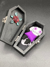 Load image into Gallery viewer, Mini socially awkward black and purple Voodoo Doll stands at 2 3/4&quot; in height.  He has a bright purple torso with black limbs and a large white head and matching purple biddy eyes.  
