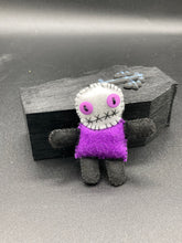 Load image into Gallery viewer, Mini socially awkward black and purple Voodoo Doll stands at 2 3/4&quot; in height.  He has a bright purple torso with black limbs and a large white head and matching purple biddy eyes.  
