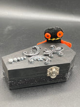 Load image into Gallery viewer, Short and tiny black and orange Voodoo Doll is 3&quot; in height.  Torso and head is all black while legs and arms are bright orange, perfect Halloween colors. He has matching bright orange buttons for eyes and has a sowed shut mouth.
