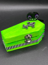 Load image into Gallery viewer, This Lime Green BeetleJuice-inspired Wood Coffin Ring Box is perfect for storing special items. The eye-catching black-silver fleur de lis embellishment and the black and white stripped ribbon gives the box a unique and spooky, yet cute and misfit look. Its all-black interior elevates the aesthetic of this stylish box.

