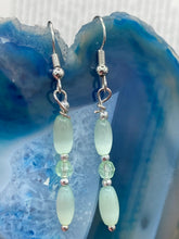 Load image into Gallery viewer, Dainty pastel green glass beaded earringsThese dainty pastel green glass beaded earrings add a unique and eye-catching touch to any look, making them the perfect bohemian accessory. Their shabby boho chic design is both comfortable and elegant, making them the ideal choice for any occasion. Measurements: 1 1/4” in length 
