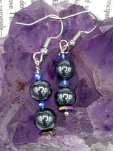 Load image into Gallery viewer, These chic earrings, crafted with two Hematite beads and blue glass beads, provide a stylish accent.  Measurements: 1 1/4” in length
