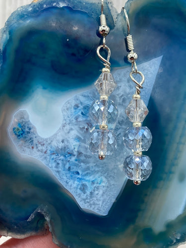 These gorgeous earrings boast three shimmering beads of round iridescent and silver glass.  Measurements: 1 1/4” in length