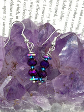 Load image into Gallery viewer, These rainbow hematite and dark purple glass beaded earrings are the ideal accessory for bohemian summer looks, providing a touch of chic elegance to hippie and nature-inspired styles.  Measurements: 1” in length
