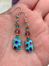 Load image into Gallery viewer, This bold and vibrant piece of jewelry features blue, purple, and gold glass beads of different sizes and shapes that are artfully combined to create a unique texture. An essential addition to any jewelry collection.  Measurements: 1 ” in length
