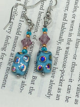 Load image into Gallery viewer, This bold and vibrant piece of jewelry features blue, purple, and gold glass beads of different sizes and shapes that are artfully combined to create a unique texture. An essential addition to any jewelry collection.  Measurements: 1 ” in length
