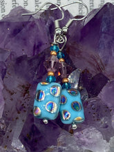 Load image into Gallery viewer, This bold and vibrant piece of jewelry features blue, purple, and gold glass beads of different sizes and shapes that are artfully combined to create a unique texture. An essential addition to any jewelry collection.  Measurements: 1 ” in length
