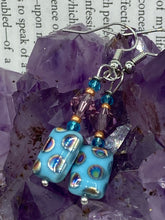 Load image into Gallery viewer, This bold and vibrant piece of jewelry features blue, purple, and gold glass beads of different sizes and shapes that are artfully combined to create a unique texture. An essential addition to any jewelry collection.  Measurements: 1 ” in length
