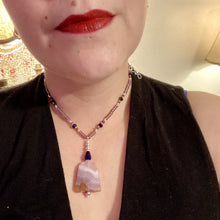 Load image into Gallery viewer, A soft dusty rose agate pendant is accompanied by shimmery beads of dusty rose, blue, dark pink, and gold. Adorned with large deep purple glass beads with a hint of gold shimmer, this stunning necklace set evokes a rose garden.  Measurements:  Necklace is 15” adjustable to 18&quot;
