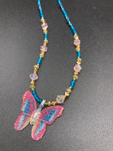 Load image into Gallery viewer, This delicate butterfly pendant is crafted from a basil leaf and adorned with accents of pink, gold and blue. A shining glass beaded necklace crafted from beads of varying shades of pink, gold, and blue, creates a beautiful accompaniment to the butterfly wings. Wear this ravishing necklace and butterfly jewelry pendant to embody the spirit of warm Spring and Summer days. 16 1/4” in length adjustable up to 18&quot;
