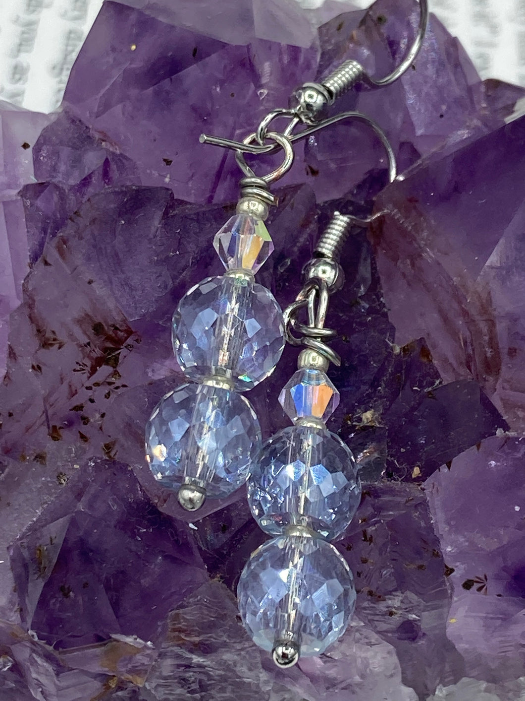 These earrings feature two shimmery iridescent glass beads with a single silver glass bead.  Measurements: 1 1/2” in length
