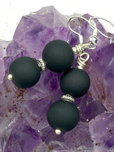 Load image into Gallery viewer, These two-bead flat matte black glass earrings are perfect for any look. With their subtle yet elegant design, they are a great accessory for any closet. 1 1/4” in length
