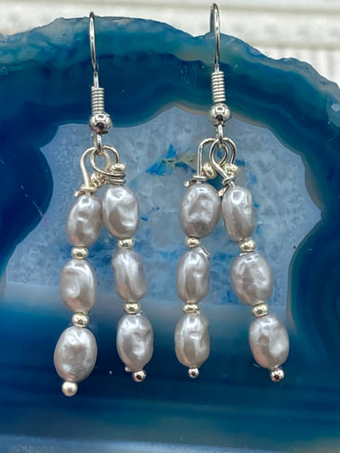 This earring set features two strands of gray faux baroque pearls and silver glass beads. Measurements: 1 1/2” in length  