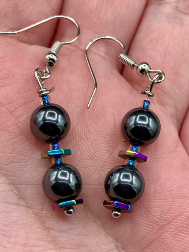 These earrings feature two round, beautiful hematite beads and hexagon-shaped rainbow hematite beads.   Measurements: 1 1/4” in length  