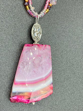 Load image into Gallery viewer, This large agate pendant features a variety of pink hues, from light to dark, and is accompanied by two strands of glass beaded necklaces with pink, silver, gold, and clear beads. The combination of colors creates a stunning and vibrant look, perfect for accessorizing any summer look.  Measurements:  Necklace is 15” adjustable up to 18&quot; in length 
