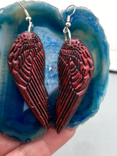 Load image into Gallery viewer, Red angel wings earrings made of polymer clay.  These earrings are designed to face forward when worn instead of the front wings showing on the side.
