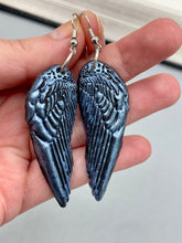 Load image into Gallery viewer, Shimmery silver color angel wings earrings made of polymer clay.  These earrings are designed to face forward when worn instead of the front wings showing on the side.
