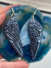 Load image into Gallery viewer, Shimmery silver color angel wings earrings made of polymer clay.  These earrings are designed to face forward when worn instead of the front wings showing on the side.
