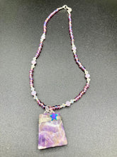 Load image into Gallery viewer, This sophisticated trapezoid-shaped wired amethyst pendant featuring a hematite star bead provides a unique, star-studded night sky look. Multicolored glass beads in shades of pink, purple, blue and gold feature along a single-stranded necklace, intermixed with larger, soft dusty rose glass beads and iridescent beads for a subtle shimmer. Necklace is 17&quot; length can be adjusted to 18&quot; 
