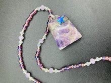 Load image into Gallery viewer, This sophisticated trapezoid-shaped wired amethyst pendant featuring a hematite star bead provides a unique, star-studded night sky look. Multicolored glass beads in shades of pink, purple, blue and gold feature along a single-stranded necklace, intermixed with larger, soft dusty rose glass beads and iridescent beads for a subtle shimmer. Necklace is 17&quot; length can be adjusted to 18&quot; 

