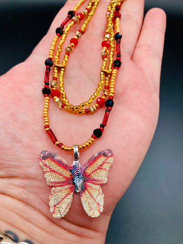 This intricately crafted pendant features a Basil leaf molded in Sterling Silver and adorned with stunningly vivid red, gold, and black glass beaded necklace. Its eye-catching butterfly design adds a bold, yet whimsical touch, making it an ideal choice for a summer look. Necklace is 15 1/2” in length adjustable to 18