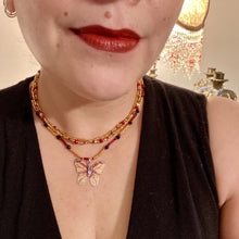 Load image into Gallery viewer, This intricately crafted pendant features a Basil leaf molded in Sterling Silver and adorned with stunningly vivid red, gold, and black glass beaded necklace. Its eye-catching butterfly design adds a bold, yet whimsical touch, making it an ideal choice for a summer look. Necklace is 15 1/2” in length adjustable to 18&quot;
