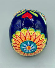 Load image into Gallery viewer, I wanted to create a skully that represented the eternal love for a special kitty cat in your life. Dark royal blue ceramic sugar skull with black cat silhouette is sitting admiring the sun going down. This Day Of The Dead ceramic skull art was created for the cat lovers who adore their sweet kitty. Measurements: H 4” x W 4” x D 5 1/2”
