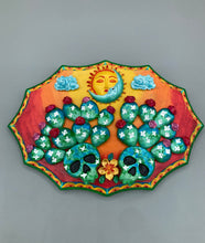 Load image into Gallery viewer, This handcrafted polymer clay wall art features a wood frame painted in a gradient from light yellow to dark red, creating a stunning sunset look. With two bright green skull cactus plant and bright dark red blooming flowers. Featuring a vivid sun and crescent moon with a backdrop of light blue clouds, this frame is sure to make an impression. A bight green hue frame to make a bold contrast with the warm background hue. This piece is sure to make a statement.
