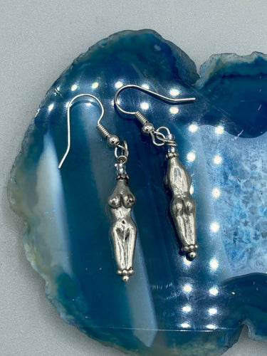 Discover these unique earrings, crafted in the shape of a female torso for a beautiful representation of the female body. Adorned with curves of love and care, these earrings make a meaningful gift.  Measurements: 1 1/2” Height