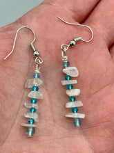 Load image into Gallery viewer, A single strand of white moonstone chip beads is accented with small light blue glass beads in these earrings, providing a nature-inspired look with a touch of bohemian vibes. Measurements: 1 1/2” in length 

