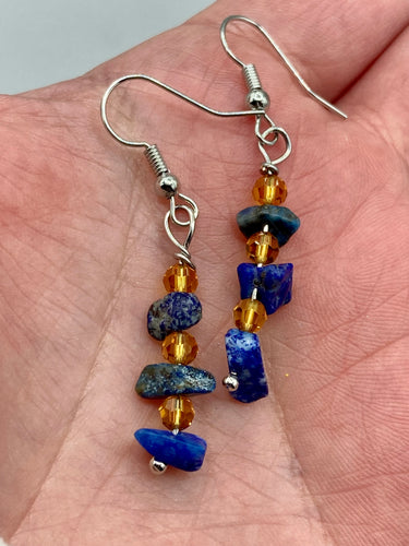 This single-stranded earring features natural lapis stone chips paired with light orange glass beads. Measurements: 1 3/16” in length  