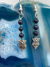 Load image into Gallery viewer, Showcasing shimmery purple goldstone beads, these classy silver-plated owl charm earrings make a statement.  Measurements: 1 3/16” in length
