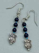 Load image into Gallery viewer, Showcasing shimmery purple goldstone beads, these classy silver-plated owl charm earrings make a statement.  Measurements: 1 3/16” in length
