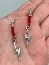 Load image into Gallery viewer, These Lightning Bolt Drop Earrings feature flat matte ruby-red glass beads and elegant lightning bolt charms. Measurements: 1 1/2” in length 
