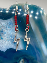 Load image into Gallery viewer, These Lightning Bolt Drop Earrings feature flat matte ruby-red glass beads and elegant lightning bolt charms. Measurements: 1 1/2” in length 
