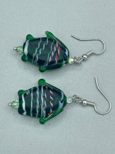 Load image into Gallery viewer, These nature-inspired glass fish earrings are the perfect addition to your boho look. Featuring a delightful dark green hue, the large puffy fish will bring a hippie vibe to your style. Measurements: 1 1/2” in length
