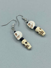 Load image into Gallery viewer, This mini howlite and bone skull bead set of earrings offers a unique touch to any goth, emo, witchy, or Day of the Dead ensemble. The black glass bead accents bring a sophisticated note to the look, and the earrings can easily be dressed up or down.  Measurements: 1 1/4 ” in length  
