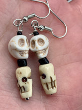 Load image into Gallery viewer, This mini howlite and bone skull bead set of earrings offers a unique touch to any goth, emo, witchy, or Day of the Dead ensemble. The black glass bead accents bring a sophisticated note to the look, and the earrings can easily be dressed up or down.  Measurements: 1 1/4 ” in length  
