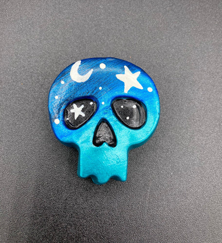 Ideal magnet design to adorn your refrigerator, lockers, workstation, toolbox, or dishwasher. This hand-sculpted clay skull statuette boasts stunning ombre coloration, transitioning from dark blue to light blue to recreate the breathtaking look of a starry night sky. H 1 1/2” x W 1 1/2” x D 3/4” 