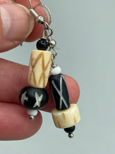 Load image into Gallery viewer, This set of earrings is crafted from a mix of bone and wood carved beads, giving it an eye-catching, one-of-a-kind look. It&#39;s versatile enough to dress up or down, making it a great choice for any occasion.  Measurements: 1 1/2 ” in length  
