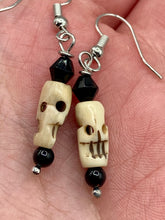 Load image into Gallery viewer, This set of mini bone skull earrings with black glass beads is an ideal addition to any gothic, emo, or witchy-inspired look. The unique day-of-the-dead aesthetic of these earrings will add a special touch to any outfit — dress them up or dress them down!   Measurements: 1 1/4 ” in length  
