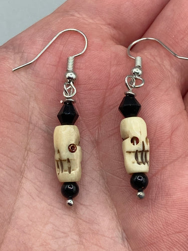 This set of mini bone skull earrings with black glass beads is an ideal addition to any gothic, emo, or witchy-inspired look. The unique day-of-the-dead aesthetic of these earrings will add a special touch to any outfit — dress them up or dress them down!   Measurements: 1 1/4 ” in length  